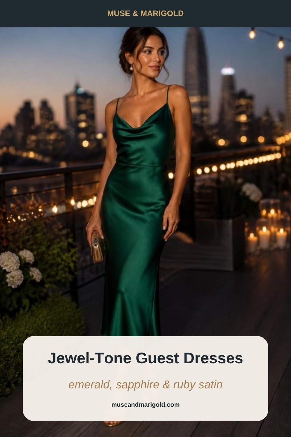 Woman in an emerald satin slip dress on a city rooftop terrace at dusk, with glowing string lights overhead
