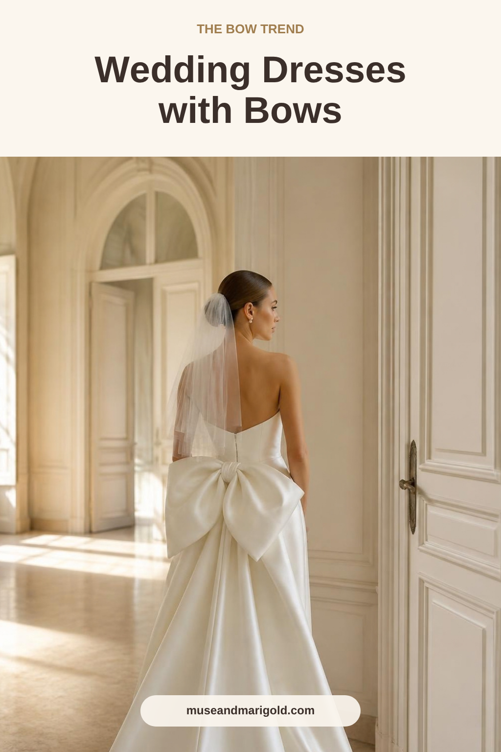 Bride in an ivory satin wedding gown with an oversized bow at the back in an elegant chateau hallway