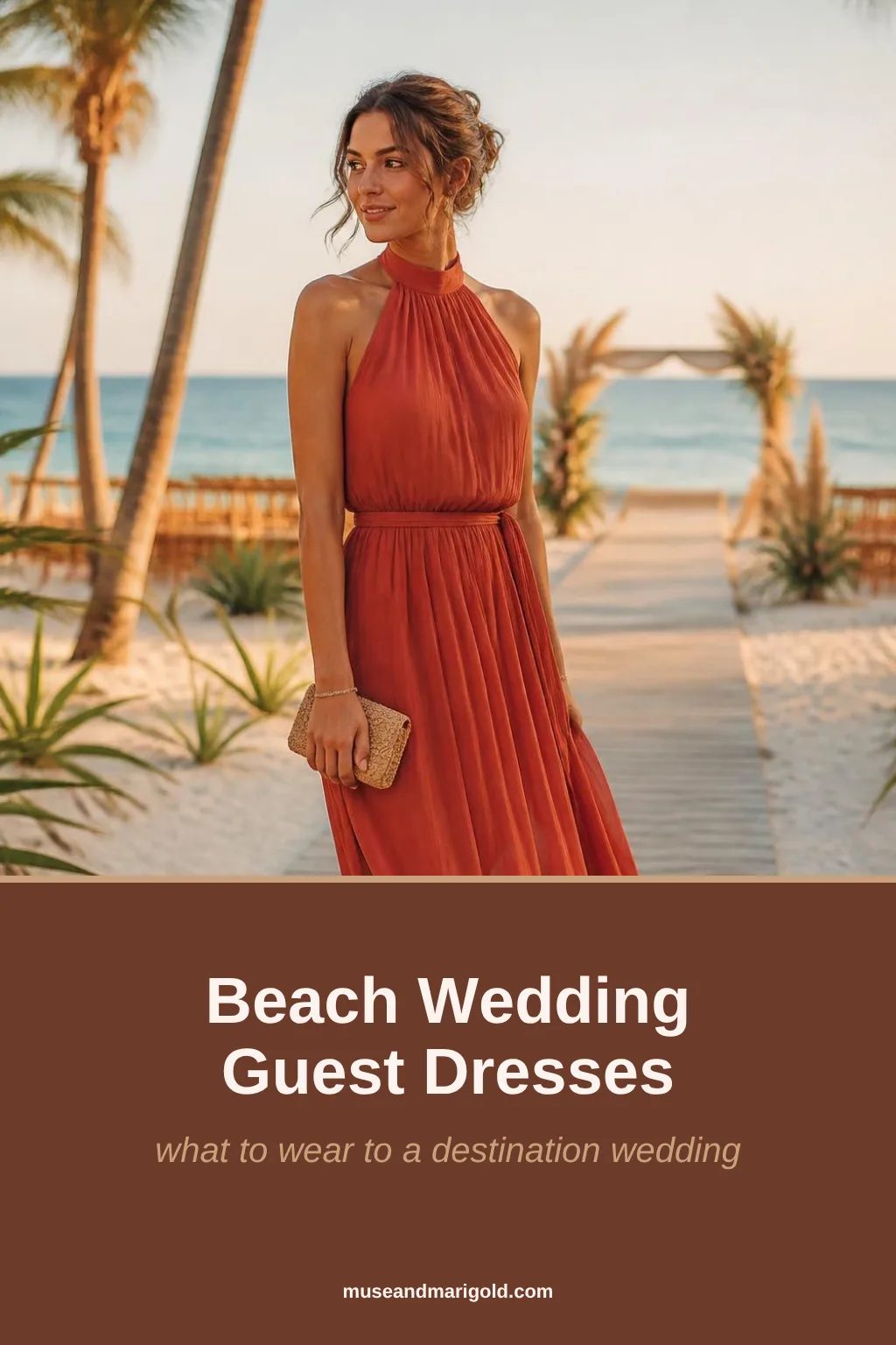 Wedding guest in a terracotta chiffon halter maxi dress on a beach boardwalk with palm trees at golden hour